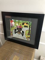Framed Maud Lewis print showing overall front view including wear on the black frame.