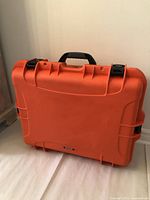 Front view of the orange Nanuk 945 hard case showing the handle and latch closures