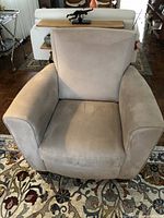 Front view of beige microfibre Natuzzi armchair showing wide armrests and cushioned seat.