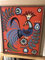 Frontal image displaying the entire needlepoint framed artwork, showing vibrant colors and composition of rooster and floral designs