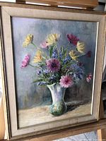 Framed oil painting showing a bouquet of colorful flowers in a vase, front view