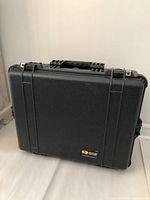 Black Pelican 1600 hard case standing upright showing front and handle.