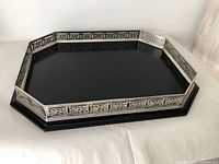 Octagonal vanity tray showing the metal filigree border and black base from an angled top view.