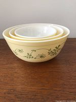 Side view of the set of three nested Pyrex Shenandoah yellow and green mixing bowls.