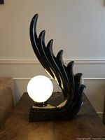 Front view showing sculptural flame base and illuminated globe