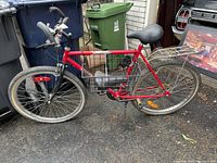 Side view of the red Venture Mountain Tour Road Runner 10 speed bike showing frame, tires, and attached rear rack and extra seat.