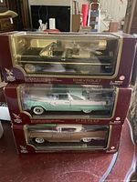 Three stacked model car boxes showing front packaging of all three models
