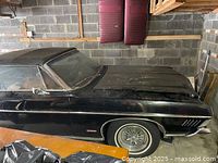 Front passenger-side view showing black body, chrome bumper and wire-spoke wheel cover