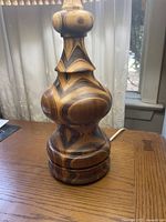 Full view of the wooden marquetry lamp base showing the multi-tone wood inlay pattern around the curved shape of the lamp.