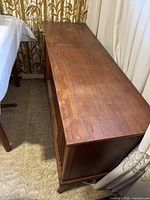Side angle view of the stereo cabinet showing wood grain and the length