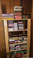 Photo of shelves with various VHS tapes, DVDs, and CDs stacked and organized