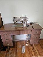 Full front view of sewing table with Pfaff 230 sewing machine, showing all drawers and pedal under table.