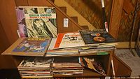 Two shelves of vintage vinyl records stacked upright and lying flat, visible album covers include Green Onions by Booker T. & the M.G.'s and others.