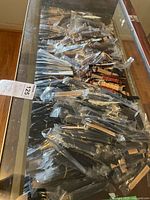 Photo showing a wide assortment of watch bands inside a display table, all in plastic sleeves.