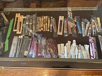 Top view of the display case with a variety of metal and leather watch bands in different colors and packaging.