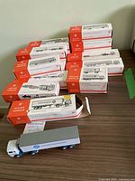 Photo showing multiple Wiking boxed model trucks arranged on a table with one truck out of box in front, labeled as Wiking Trucks.