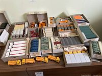 Overview of multiple small boxes containing plastic vehicle models on tabletop