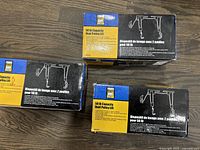 Three boxed Power Fist dual pulley lifts stacked on a wooden floor.