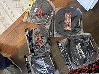 Five pairs of headrest covers laid on floor, visible packaging. Teams: Calgary Flames, Vancouver Canucks, Ottawa Senators, Toronto Raptors, Edmonton Oilers.