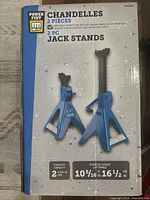 Front of the Power Fist box showing two blue jack stands, capacity 2 ton, lift range 10 5/16 to 16 1/2 inches, brand and product name