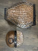 Overhead view of the hammered copper umbrella stand and smaller planter/holder showing overall shape and rivet pattern.