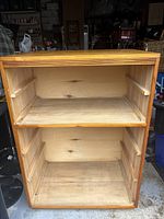 Open dresser showing two empty drawers and wooden frame interior