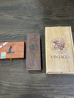 Three vintage wooden boxes arranged on wood surface: Vintages box, Albert Springs box, and cigar box