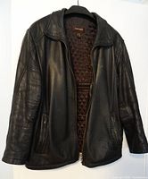 Front exterior view of black Danier genuine leather jacket showing zippered pockets and collar.