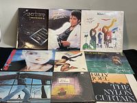 Photo showing all nine vinyl record covers arranged in two rows, featuring Michael Jackson Thriller, ABBA, Supertramp, Billy Joel, Eurythmics, and others