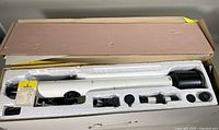 White TASCO refractor telescope and accessories set in original styrofoam packaging inside original box.