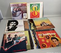 Six vintage vinyl records displayed on table, showing front album covers for various classic artists and soundtracks.