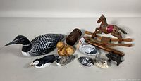Overview of all vintage wooden folk art bird carvings and the signed Marie Vail mantle rocking horse. Shows the variety of bird species represented and the rocking horse condition.
