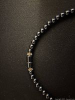 Close-up image of the necklace beads and cylindrical hematite clasp portion showing bead detail and clasp type.