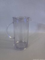 Clear plastic pitcher with lid shown from front, highlighting handle and clear body.