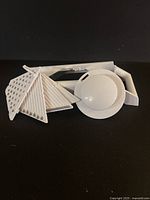 White Fox Run mandoline slicer laid flat showing all four detachable blades and circular handguard.