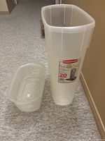 Photo of tall opaque plastic storage container and lid, showing size and shape for wrapping paper storage