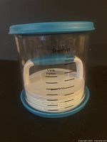 Starfrit branded hamburger press inside clear container with blue lid, visible size markings for 1/4 lb and 1/3 lb patties