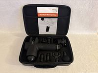 Wattne W2 handheld massage gun with six attachments and charger inside the opened carrying case, showing all contents.
