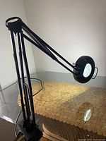 Side view showing adjustable arm and clamp mount attached to table edge.