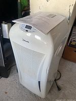 White Silhouette branded dehumidifier with digital control panel and accompanying manual on top.