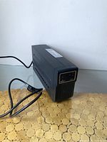 Front angle view of Emerson Liebert PSA AC power backup unit showing attached power cord resting on a table.