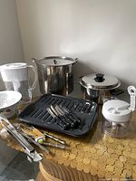 Various kitchen utensils and cookware including pots, a grill pan, and small kitchen tools shown separately.