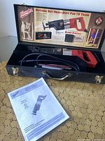 Milwaukee Super Sawzall reciprocating saw in metal carrying case with instruction manual visible.
