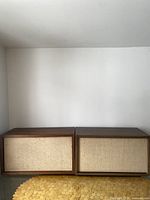 Front view of the pair of vintage speakers side by side, showing wooden cases and beige cloth front covers.