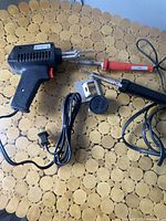 Lot of three soldering irons on table showing all items and power cords