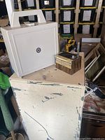 Photo showing weather alert radio in beige plastic case with handle, vintage navigational sextant, and metal chest with worn cream paint.