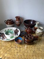 Overview of entire lot showing multiple vintage pottery pieces including Robinson Ransbottom Bead Pot, decorative platter, vases, bowls, and jugs