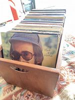 Wooden box filled with vinyl records, front view showing cut-out handle