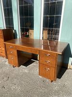 Full front view of the vintage wooden desk showing the six drawers and solid wood construction.