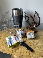 Photo showing electric wine chiller, metal 6 bottle caddy, wooden wine bottle holder, multiple wine accessories including colorful markers, stoppers, plastic glass holders and opener.